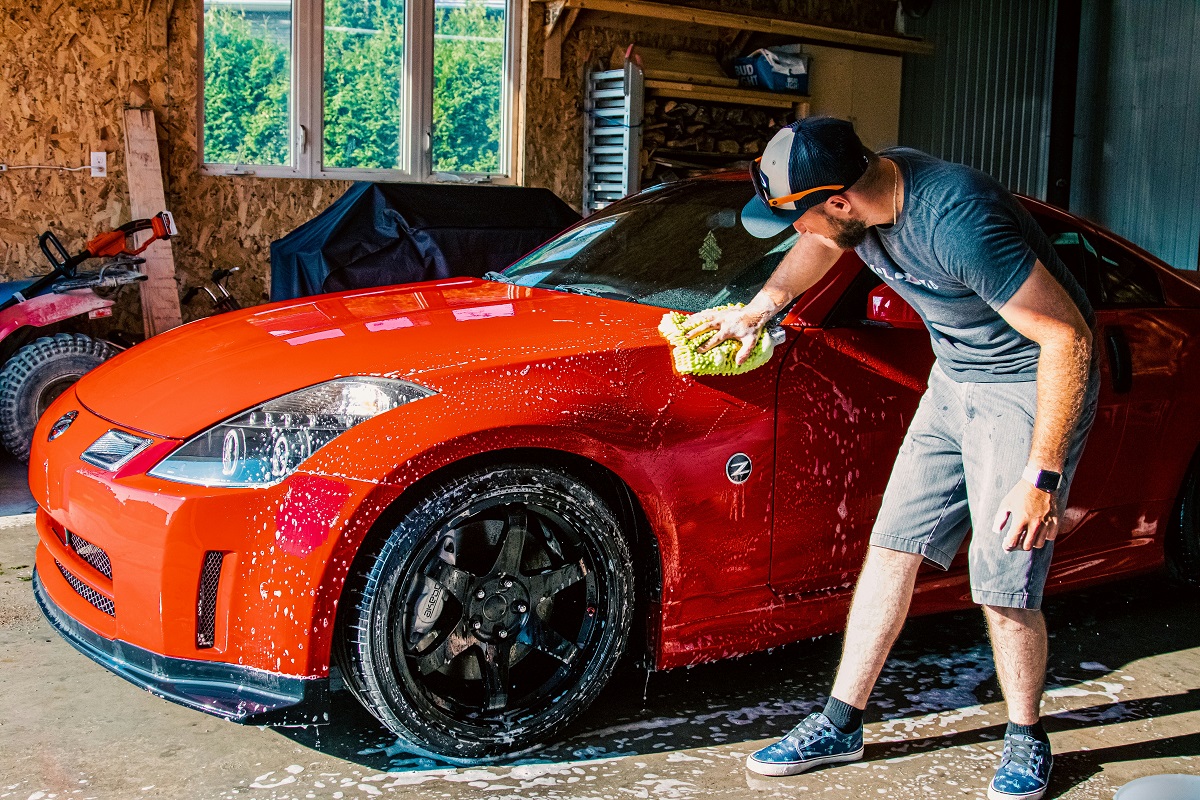 man washing his car in a garage